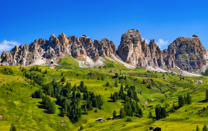 Dolomiten mit grünen Wiesen und Berghütten