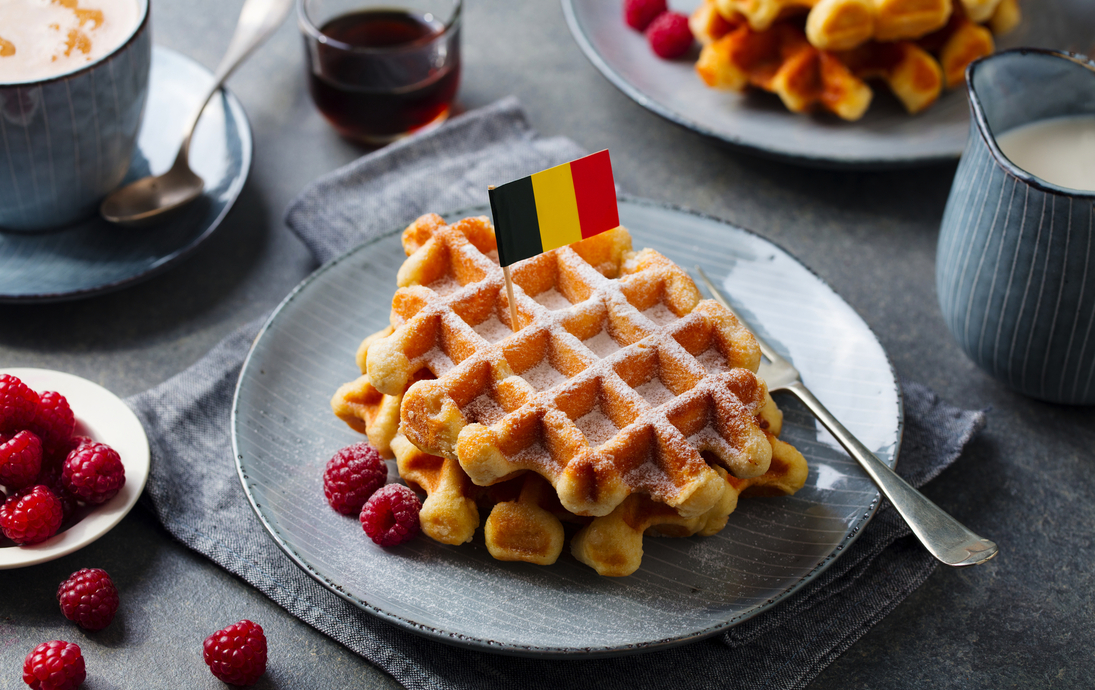 Waffeln mit Puderzucker und Belgien-Flagge auf einem Teller