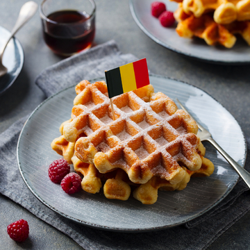 Waffeln mit Puderzucker und Belgien-Flagge auf einem Teller - ©annapustynnikova - stock.adobe.com