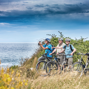 Urlauber auf einer Biketour am Meer
