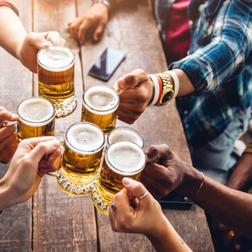 Eine Gruppe von Leuten genießt und stößt mit einem Bier in der Brauereigaststätte an. - © Davide Angelini - stock.adobe.com