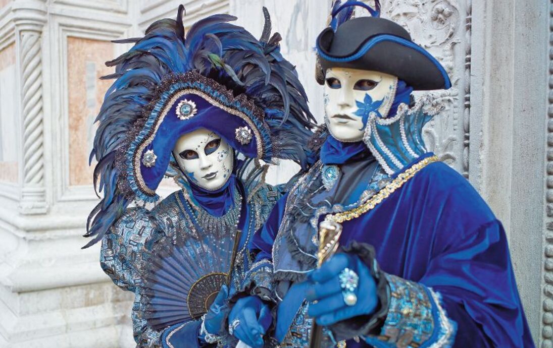 Person in Venetian costume attends Carnival of Venice.